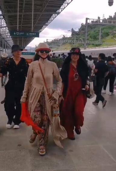 杨丽萍三姐妹回家探亲，走在火车站如同走秀，不戴口罩引争议